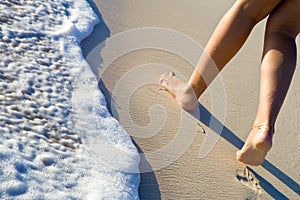 Two women legs walking on sand beach