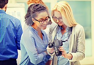 Two women looking at digital camera at office