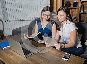 Two women managers preparing to conference using net-book and touch pad