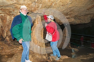 Two women, members of the tourist group, pose against the backdrop of the cave. Red Cave