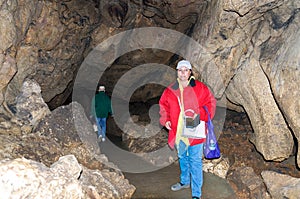 Two women, members of the tourist group, pose against the backdrop of the cave. Red Cave