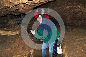 Two women, members of the tourist group, pose against the backdrop of the cave. Red Cave