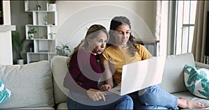 Two women, mom and daughter discuss on-line purchase using laptop