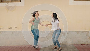 Two women mother and daughter smiling confident jumping at street