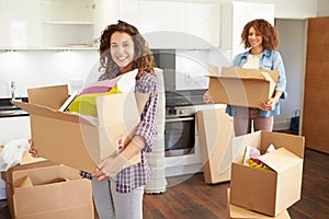 Two Women Moving Into New Home And Unpacking Boxes