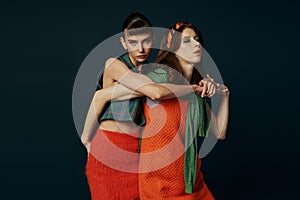 Two women in orange skirts hugging photo