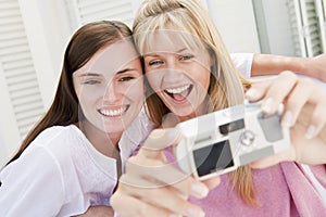 Two women on patio using digital camera