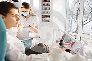 Two women on pedicure procedure in beauty salon
