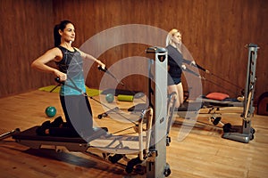 Two women on pilates training in gym, flexibility