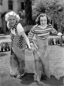 Two women playing a game of potato sack racing photo