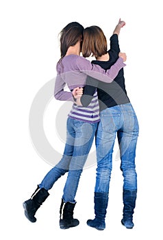 Two women pointing at wall. Rear view.