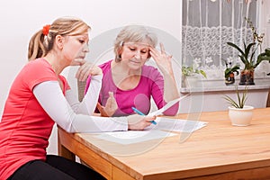 Two women pondering over documents