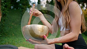 Two Women practice yoga with standing or resting bell, singing bowl in park