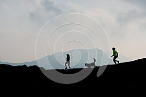 Two women race in the mountains with a dog