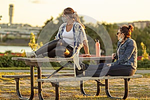 Two women are relaxing at Gravelly Point park at sunset