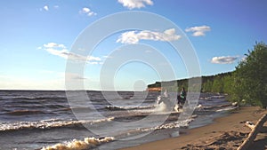 Two women ride on horse at river beach in water sunset light