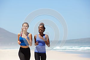 Two women running at the beach in summer