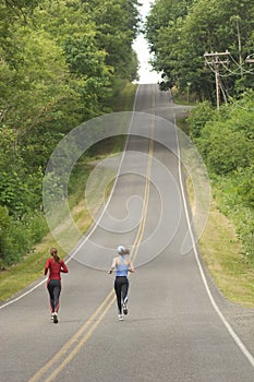 Two women running on rural road