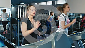 Two women running on the treadmill in the gym
