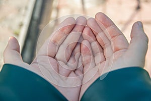 Two women`s hands are folded in a boat asking for alms. Selective focus