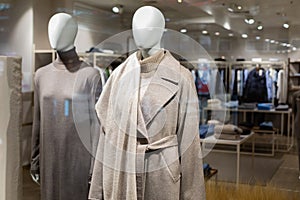 Two women& x27;s mannequins in the window of a large outerwear store. Autumn winter coat on them