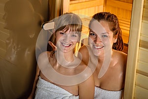 Two women at sauna wrapped in towel