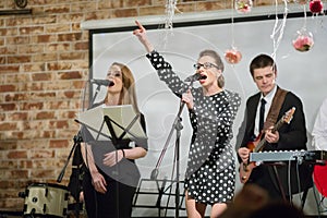 Two women sing and two men play music ob stage photo