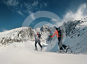 Two women ski walkers go up on the mountain top