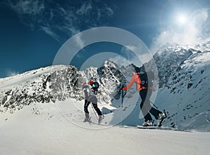 Two women ski walkers go up on the mountain top photo