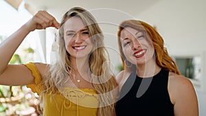 Two women smiling confident holding key of new home at home terrace