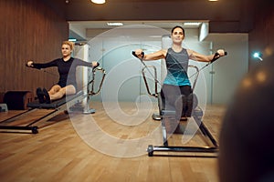 Two women in sportswear, pilates training in gym