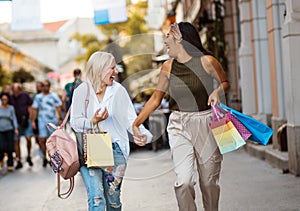 Two women on street carrying shopping bags Funny weekend