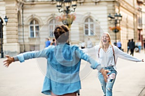 Two women on the street. They run into each other`s arms Friendly hug