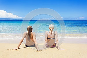 Two women sun tanning on a sunny beautiful beach