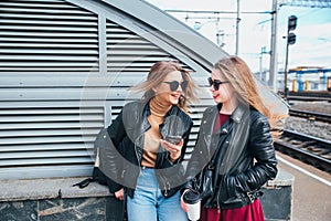 Two Women Talking in the City.Outdoor lifestyle portrait of two best friends hipster girls wearing stylish Leather