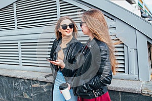 Two Women Talking in the City.Outdoor lifestyle portrait of two best friends hipster girls wearing stylish Leather