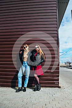 Two Women Talking in the City.Outdoor lifestyle portrait of two best friends hipster girls wearing stylish Leather