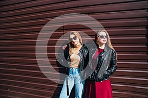 Two Women Talking in the City.Outdoor lifestyle portrait of two best friends hipster girls wearing stylish Leather