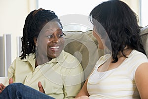 Two women talking in living room and smiling