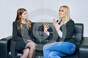 Two women are talking on the sofa