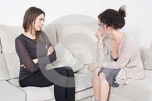 Two women talking on a sofa photo