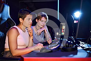 Two women with tattoos concentrating on