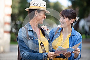 two women tourists using map in city