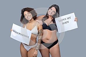 Two women in underwear with posters in their hands. photo