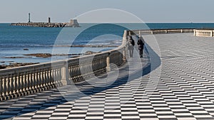 Two women walk on the Mascagni Terrace in Livorno on a beautiful sunny day, Tuscany, Italy