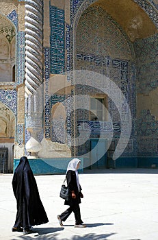 Two women walk past the Shrine of Khwaja Abu Nasr Parsa or Green Mosque in Balkh, Afghanistan