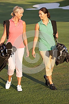 Two Women Walking Along Golf Course photo