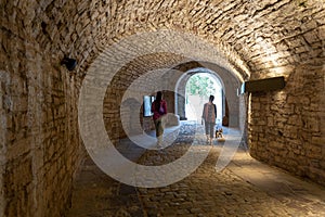 Two women are walking in an ancient tunnel