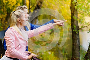 Two women walking in autumn park
