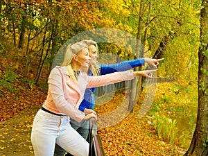 Two women walking in autumn park